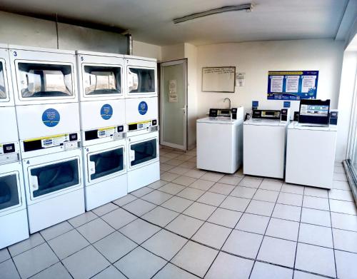 a laundry room with white washers and dryers at Cómodo Departamento (Estación Central) in Santiago