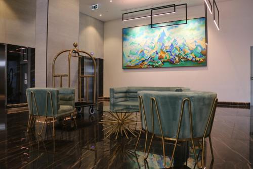 a lobby with two chairs and a painting on the wall at Kooii Apartments in Brisbane