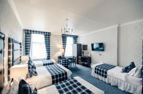 a hotel room with two beds and a couch at Argyll Hotel in Glasgow