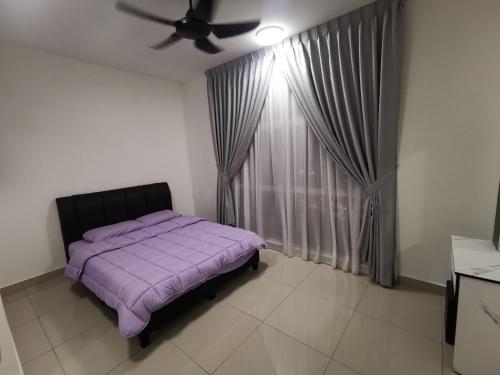 um quarto com uma cama roxa e uma janela em D Putra Suites @ IOI Mall Kulai em Kulai