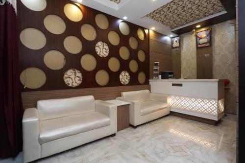 un salón con 2 sillas blancas y un mostrador en Hotel Us Residency en Kakarmatha
