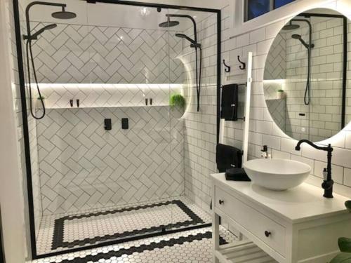 La salle de bains est pourvue d'une douche, d'un lavabo et d'un miroir. dans l'établissement Hamptons In Rye Green Cottage 3 Mins to Hot Springs!, à Rye