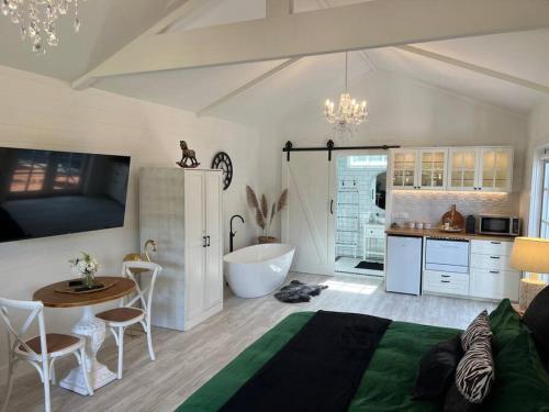 a bedroom with a bed and a bathroom with a tub at Hamptons In Rye Green Cottage 3 Mins to Hot Springs! in Rye