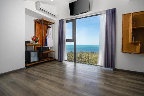 a living room with a large sliding glass door at Sala Tuy Hoa Beach Hotel in Tuy Hoa