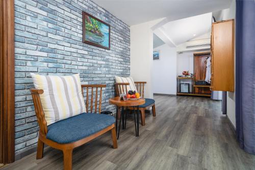 a living room with chairs and a brick wall at Sala Tuy Hoa Beach Hotel in Tuy Hoa