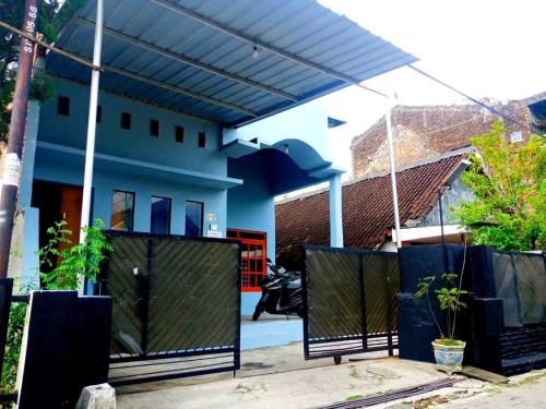 ein Haus mit einem schwarzen Tor davor in der Unterkunft Kost Harian Semarang Murah in Semarang