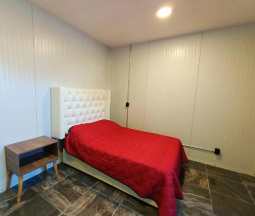 um quarto com uma cama vermelha e uma mesa em Suite Aries em Tlatlauquitepec