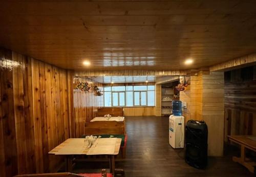 a room with wooden walls and a table and a refrigerator at Mount Khang Hotel in Lachen