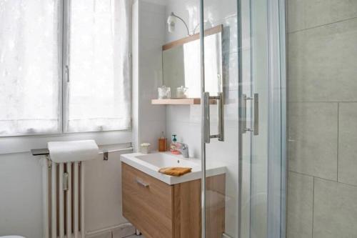 een badkamer met een wastafel en een glazen douche bij T1 cocooning à l’Hôtel de Ville in Charleville-Mézières