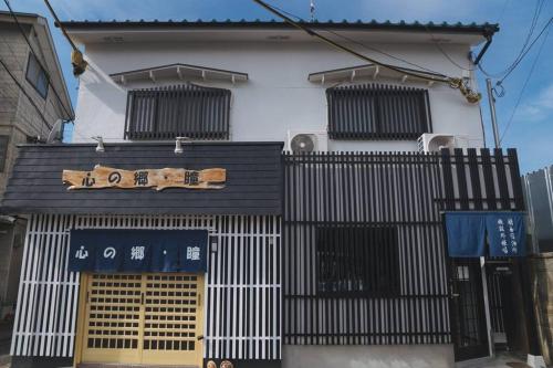 a building with a sign on the side of it at Kokoro no sato・Hitomi in Kyoto