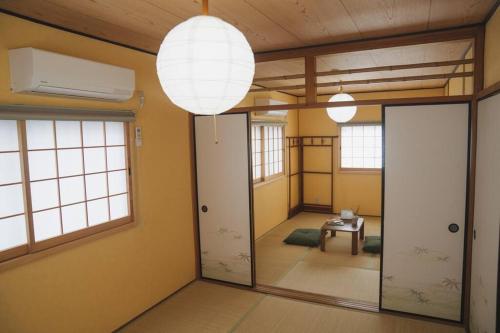 a room with two doors and a table and windows at Kokoro no sato・Hitomi in Kyoto