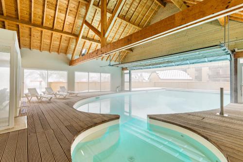 ルションにあるLagrange Vacances Les Pics d'Aranの木製天井の家のスイミングプール