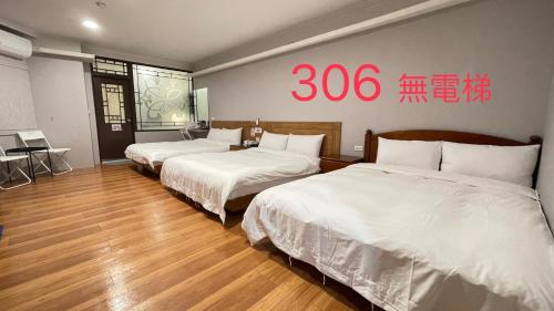 two beds in a room with a sign on the wall at 町宿溫泉旅館 in Jiaoxi