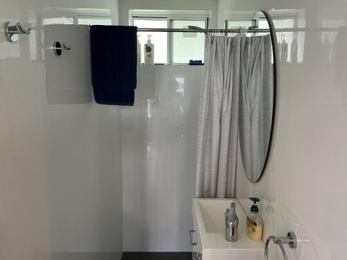 ein weißes Bad mit einem Waschbecken und einer Dusche in der Unterkunft ADEL86 - Twin Rivers in Greenwell Point