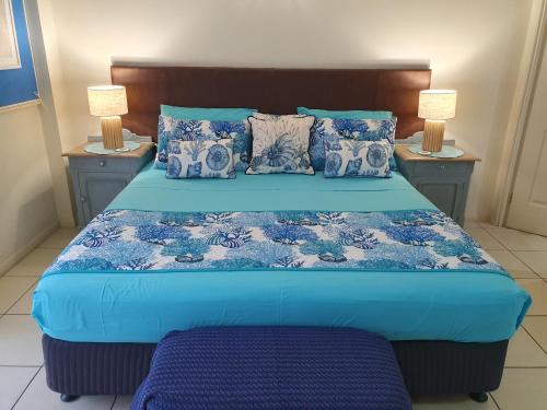 una camera con letto blu e due comodini di Jackies Studio Apartment a Cairns