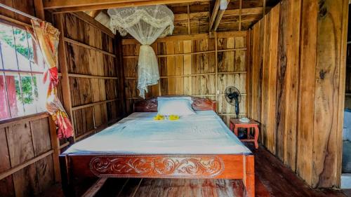 ein Schlafzimmer mit einem Bett in einem Holzzimmer in der Unterkunft Sok Mean Bungalows in Koh Rong Sanloem