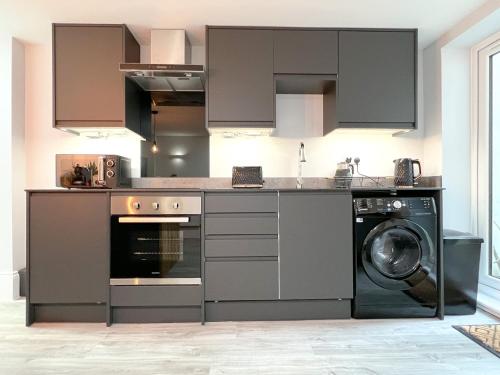 a kitchen with a washer and a washing machine at The Bohemian Basement in Kent