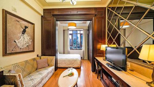 a living room with a couch and a television at Yeoksam Artnouveau City Hotel and Residence in Seoul