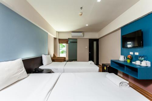 Habitación de hotel con 2 camas y TV en Solace at Srinakarin Hotel en Bangna