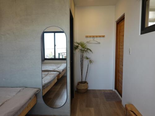 a mirror in a room with a bed and a window at Summerflow Hostel in Xiaoliuqiu