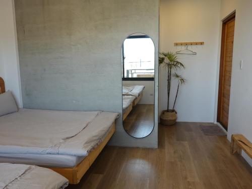 a room with two beds and a mirror at Summerflow Hostel in Xiaoliuqiu