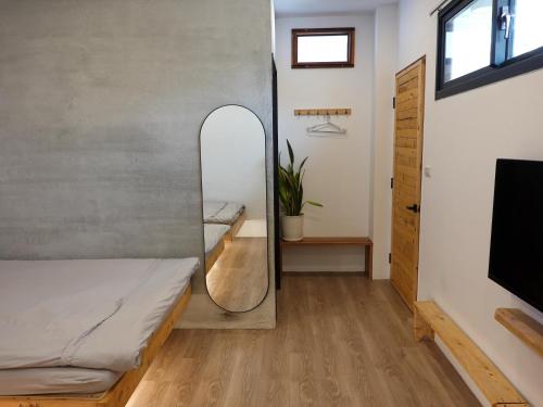 a room with a bed and a mirror at Summerflow Hostel in Xiaoliuqiu