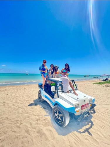 a group of people riding in a jeep on the beach at Zuri Pousada Maragogi in Maragogi