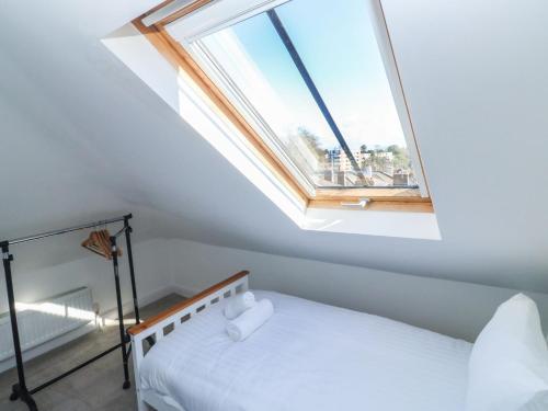 een slaapkamer op zolder met een dakraam en een bed bij 1 Kents Mews in Torquay