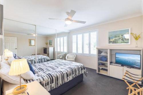 a bedroom with two beds and a flat screen tv at Laman Lodge 6 spectacular views and Aircon in Nelson Bay