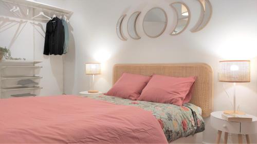 um quarto com uma cama cor-de-rosa e 2 almofadas cor-de-rosa em Apartamento Elena - coqueto, tranquilo y céntrico em Múrcia