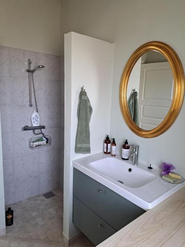 ein Badezimmer mit einem großen weißen Waschbecken und einem Spiegel in der Unterkunft Eltvedhus Feriebolig in Hjørring
