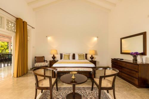 a bedroom with a bed and a table and chairs at Villa Labugolla in Kandy