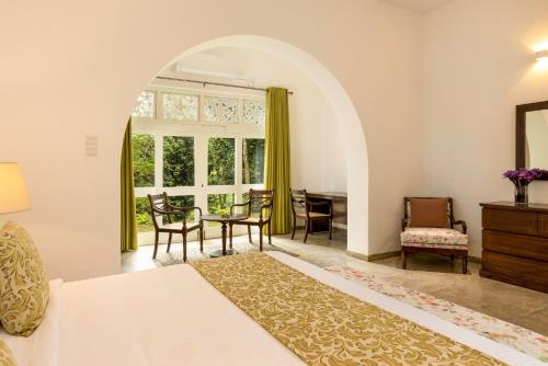 a bedroom with a bed and a table and chairs at Villa Labugolla in Kandy