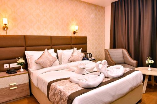 two swans sitting on a bed in a hotel room at Rufina Pinasa Residency in Gangtok