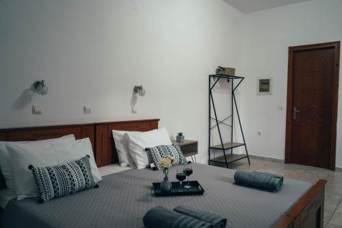 Schlafzimmer mit einem Bett und einem Tablett mit Weingläsern in der Unterkunft DANDOLOS STUDIOS in Parga