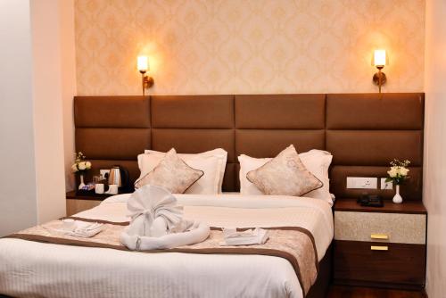 a hotel room with two beds with a large headboard at Rufina Pinasa Residency in Gangtok