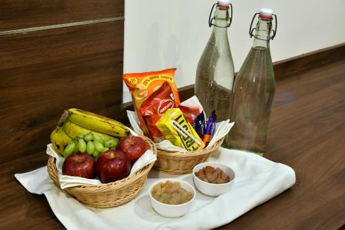 a table with baskets of fruit and snacks and bottles at Rufina Pinasa Residency in Gangtok
