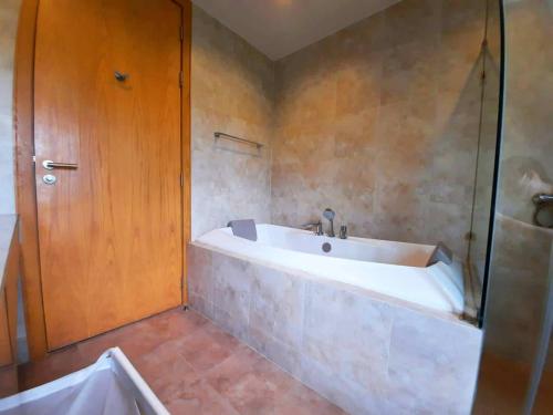 a bathroom with a bath tub and a shower at Sandbox frontbeach villa4 in Bang Lamung