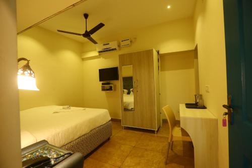 a hotel room with a bed and a desk with a sink at Zingle Stay Airport Hotel in Chennai