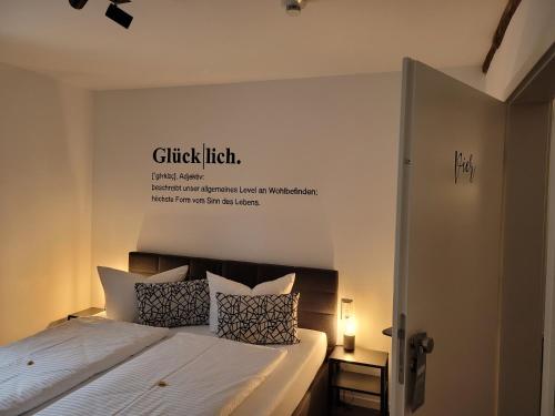 um quarto com uma cama com uma placa na parede em Hotel Apartment Ferienwohnung Meyenhof Frankenberg Eder em Frankenberg