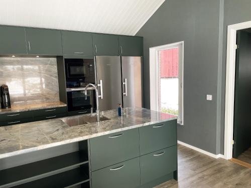 a kitchen with green cabinets and a sink at Fantastic holiday home with own lake plot by Bolmen, Ljungby in Ljungby