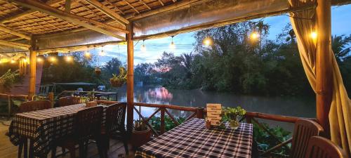 a patio with a table and chairs and a view of a river at Song Ngư Riverside Homestay in Can Tho