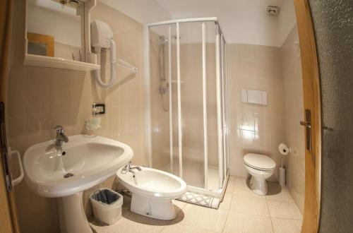 uma casa de banho com um chuveiro, um lavatório e um WC. em B&B Casa Zeni em Faedo