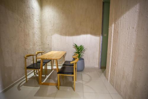 a table and two chairs and a potted plant at The Cave By Cactus Hotel Skudai in Skudai