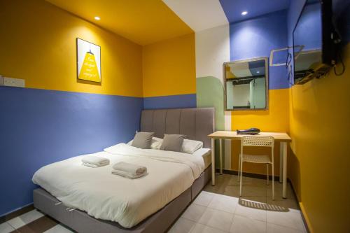 a bedroom with a bed and a desk in it at The Cave By Cactus Hotel Skudai in Skudai