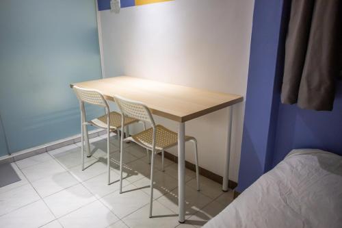 a table and two chairs in a room at The Cave By Cactus Hotel Skudai in Skudai