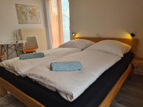 een groot wit bed met 2 kussens erop bij Lichtdurchflutetes Zimmer - Mainwiesen in Waldbüttelbrunn