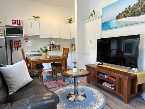 sala de estar con sofá y TV en One Bedroom Apartment on Summer/ No.2 near CBD en Orange