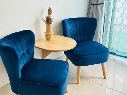 two blue chairs and a table with a vase at Tessa's on the Beach in Gold Coast