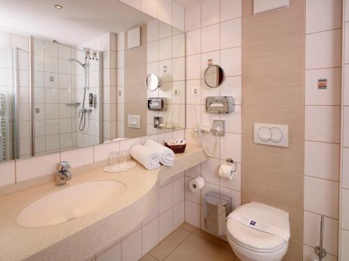 バート・ヴィンツハイムにあるKurhotel Pyramide Bad Windsheimのバスルーム(洗面台、トイレ、鏡付)